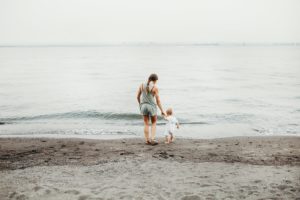 mother and child standing on the water's edge
