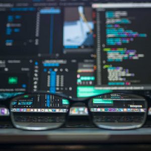 A pair of glasses in front of a computer