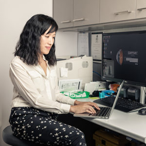 Dr Jennifer Fan Gaskin working at her desk using a laptop