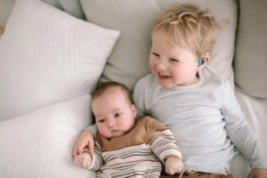 Toddler Noah Aldermann and his baby sister Olive. Noah is wearing a hearing aid.