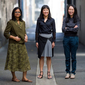 Photograph of Dr Manisha Shah, Dr Jennifer Fan Gaskin and Dr Elsa Chan standing face to camera in a laneway.