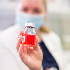 Photo of a scientist holding a donor cornea.
