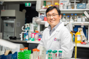 Photo of Associate Professor Rick Liu sitting at a lab bench surrounded by equipment.