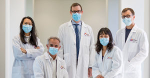 Photograph of some of CERA's glaucoma researchers, wearing lab coats, standing face to camera in a corridor at the CERA offices.