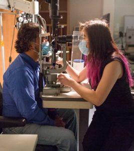 Photograph of Dr Flora Hui examining a patient in a consultation room.