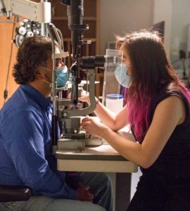 Photograph of Dr Flora Hui examining a patient in a consultation room.