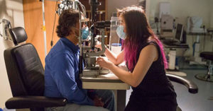 Photograph of Dr Flora Hui examining a patient in a consultation room.