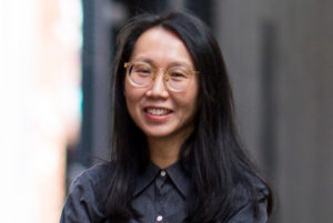 Head and shoulders photograph of Dr Elsa Chan standing outdoors, face to camera, smiling.