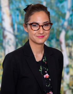 Head and shoulders photograph of Dr Michelle Waugh standing face to camera, smiling.