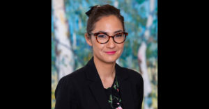 Head and shoulders photograph of Dr Michelle Waugh standing face to camera, smiling.