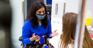 Photograph of Dr Srujana Sahebjada talking to a trial participant in an examination room.