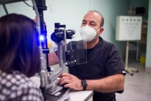 Marios Constantinou using a slit lamp to examine a patient's eye