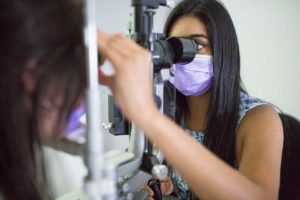 Optometrist Bhaj Grewal examines a patient through a slit-lamp