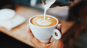 Frothed milk being poured into a coffee