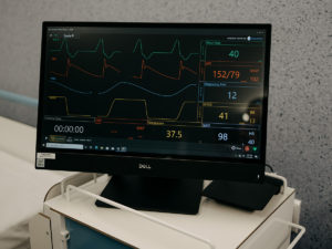 A monitor on a hospital bed table showing health data