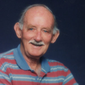 A portrait of Geoff Burfoot, wearing a striped blue and red polo shirt