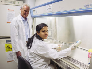 Associate Professor Ian Trounce and Dr Sushma Anand in the lab turning towards the camera and smiling.