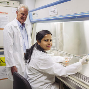 Associate Professor Ian Trounce and Dr Sushma Anand in the lab turning towards the camera and smiling.
