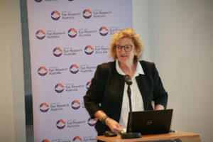 Professor Robyn Guymer AM standing and speaking from a lecturn