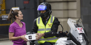 LEDS Coordinator Prue Armstrong hands over the precious cargo to Bloodbikes volunteer Rob Chrisomalidis