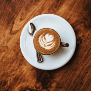 Top-down view of coffee cup with saucer and spoon.